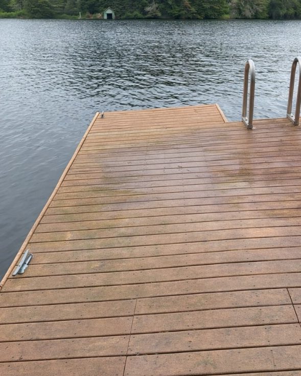 A wooden lake dock, weathered and dark