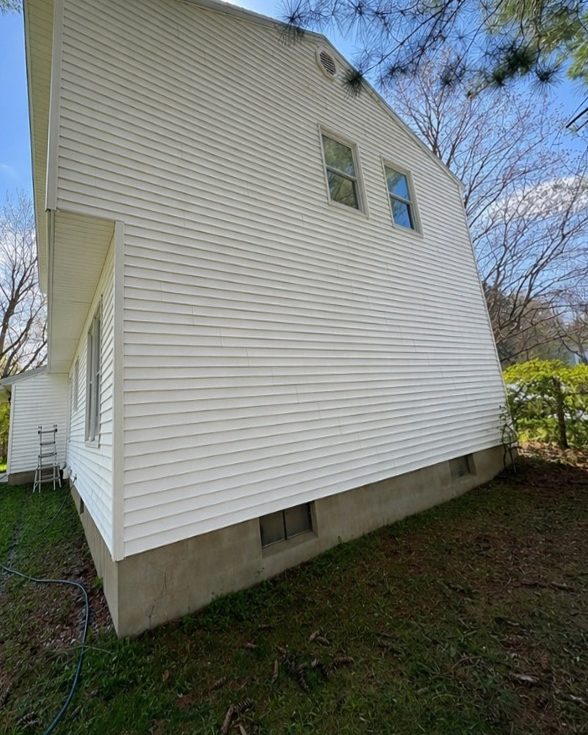 The same side of the house after a house wash, bright white siding
